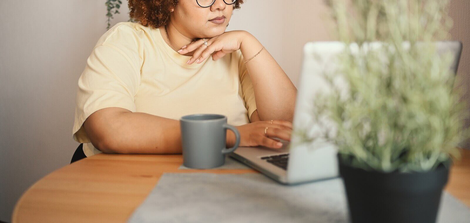 A woman sits at a table while looking at her laptop. Looking for Online Therapy in Austin, TX? Speak with an online therapist in texas to see if it is right for you!