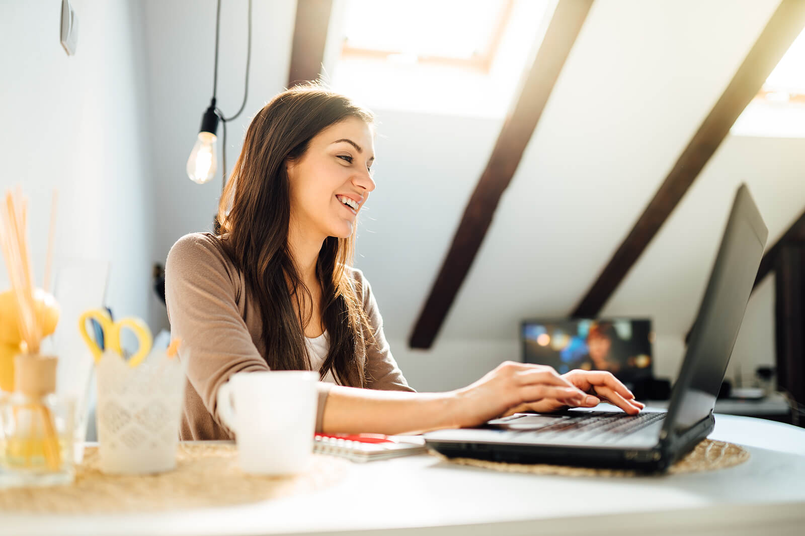 A woman types on her laptop while sitting at her desk. Searching for online therapy in Austin, TX? Our experienced online therapist in Texas can help you heal from trauma. Visit us today! 