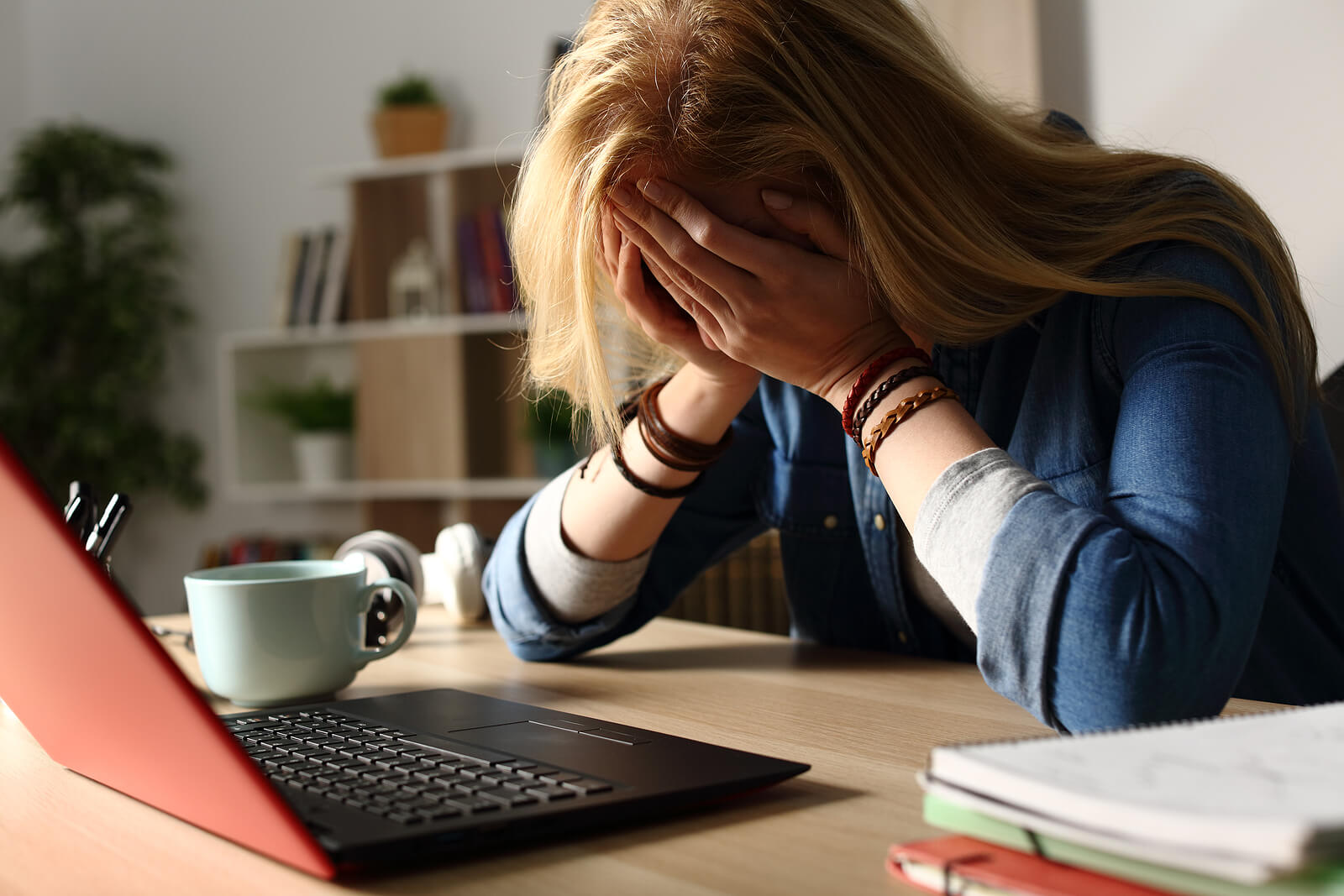 A woman cries into her hands in front of her laptop. Looking to move past your trust issues through online therapy in austin, tx? Speak with an online therapist in Texas to learn if it is right for you!