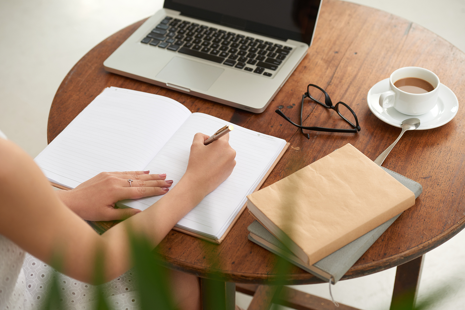 A woman sits at a desk writing in a journal in front of her laptop. Looking for trauma therapy in Austin, TX? Our trauma therapist can help you heal from your emotional abuse in Austin, TX. Visit us today!
