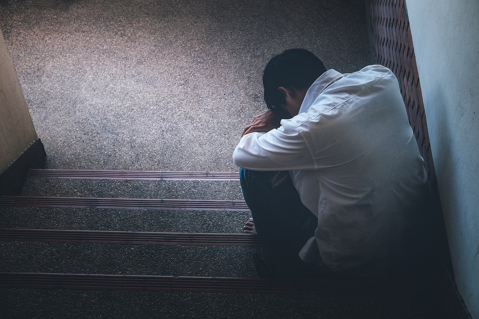 A sad man is sitting on stairs and crying. Looking to heal from your relational trauma in Austin, TX? Individual therapy for relationship issues in Texas can help you.