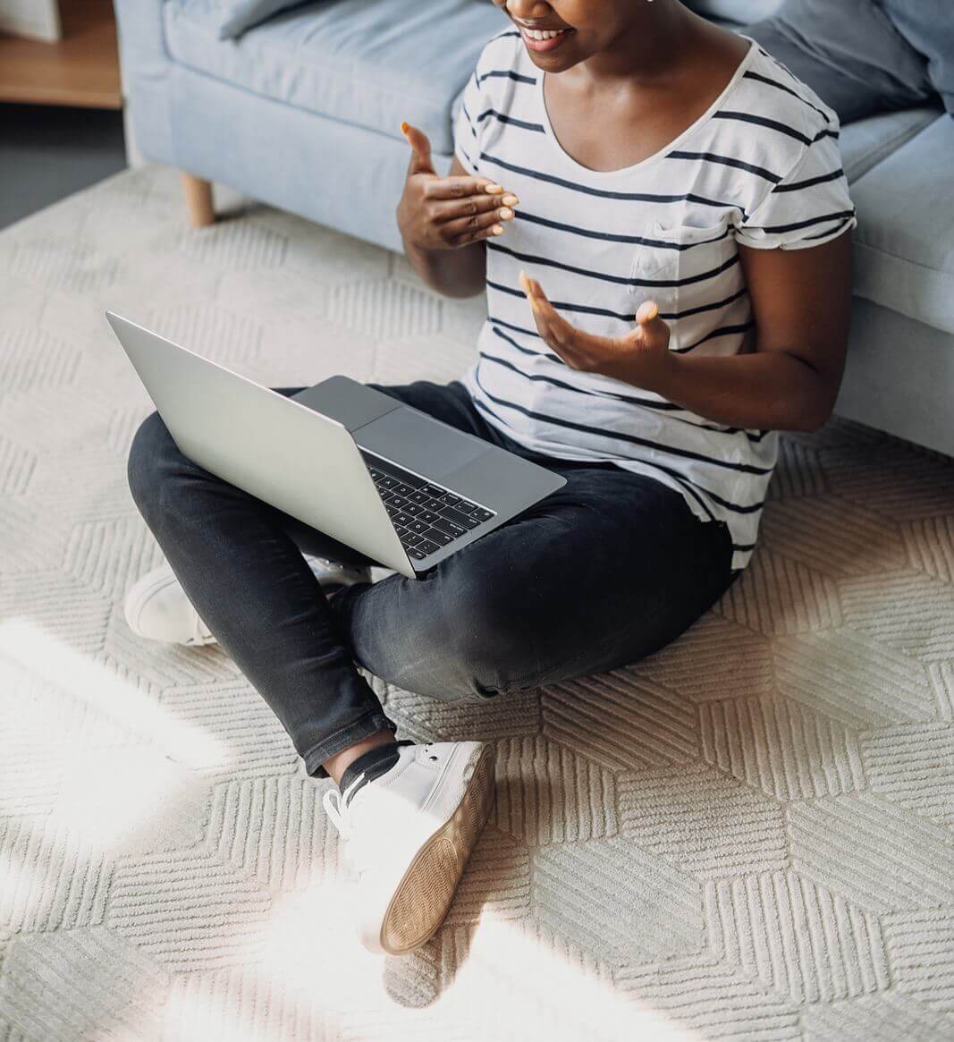 A woman sits on the floor while speaking through her laptop. Seeking depth therapy in Austin, TX? Speak with a depth therapist who can help you figure out what you need.