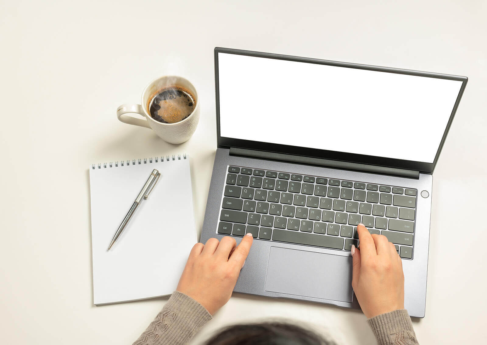 A person's hands typing on a laptop with a notebook by their side. Looking to learn how to cope with your trauma? Our experienced online therapist can teach you. Try online therapy in Austin, TX today!