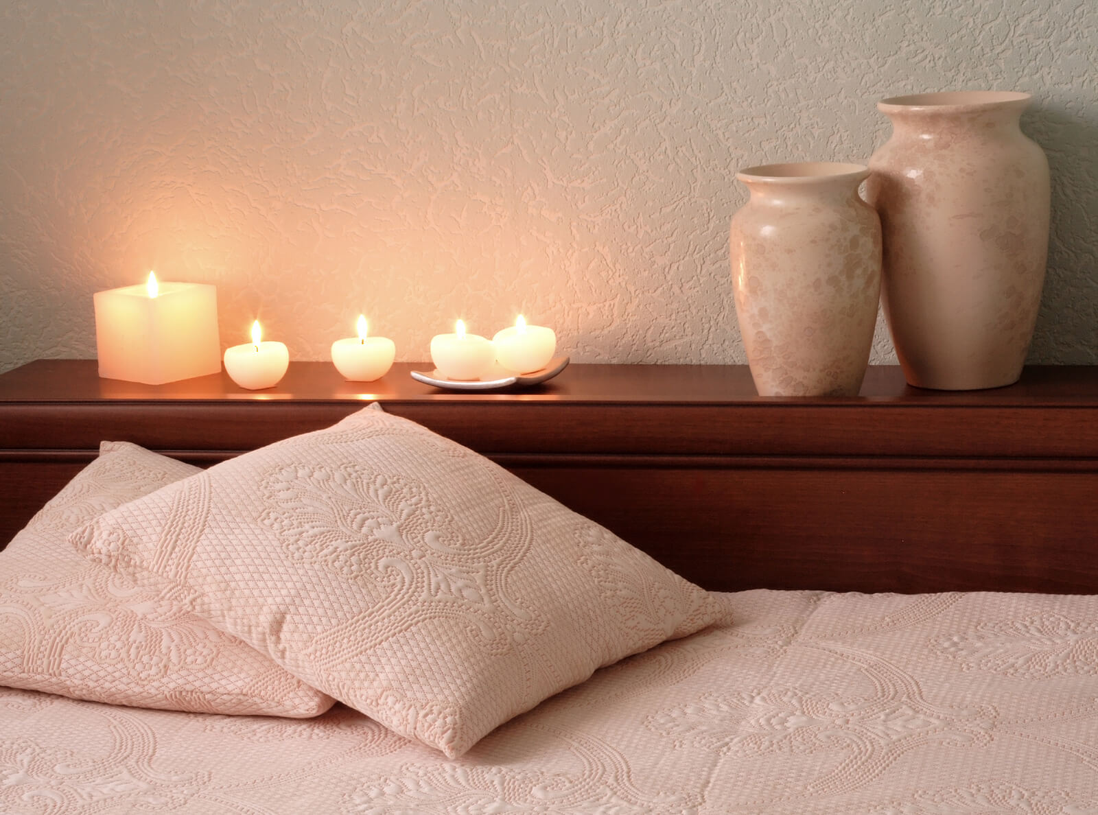 A set of candles and vases around a bed with pillows. Are you looking to explore yourself? Depth therapy in Austin, TX could be right for you. Speak with an online psychotherapist in Texas today. 
