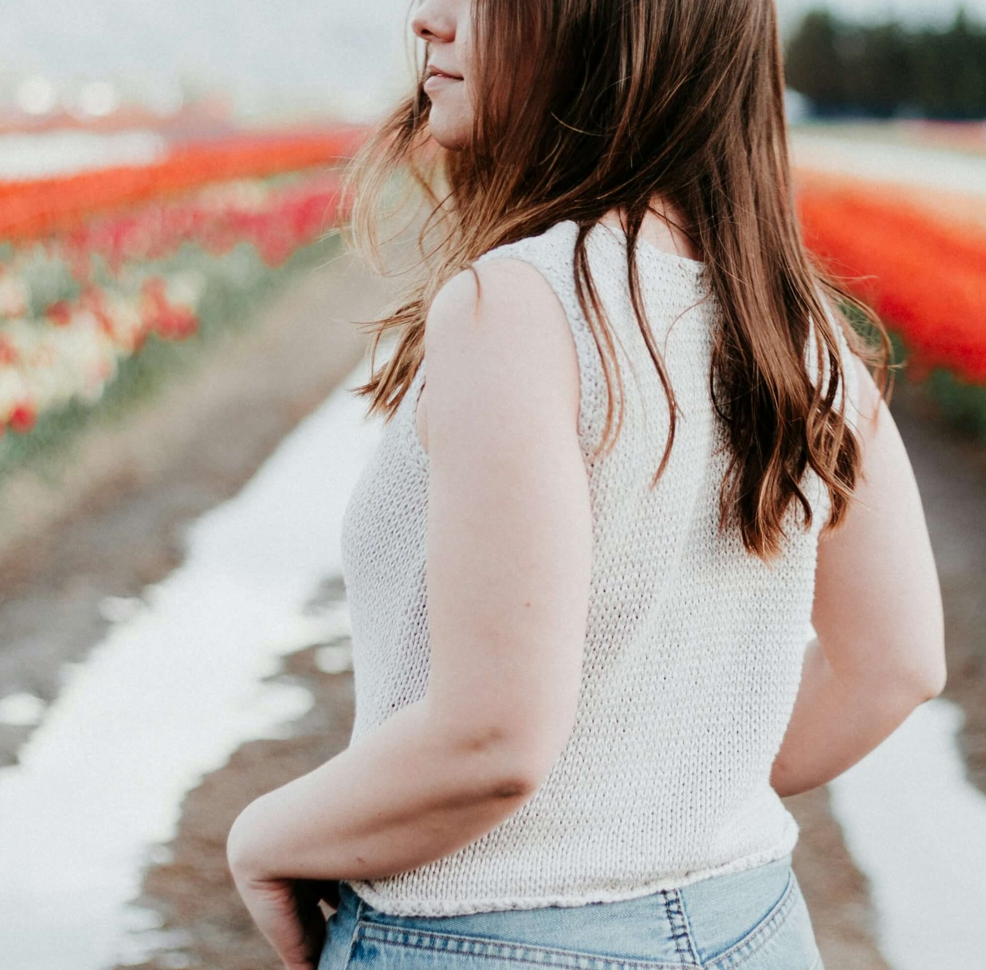 Image of a happy woman standing in a field of flowers. Discover how gaslighting can cause relationship trauma and how trauma therapy in Austin, TX can help you cope.