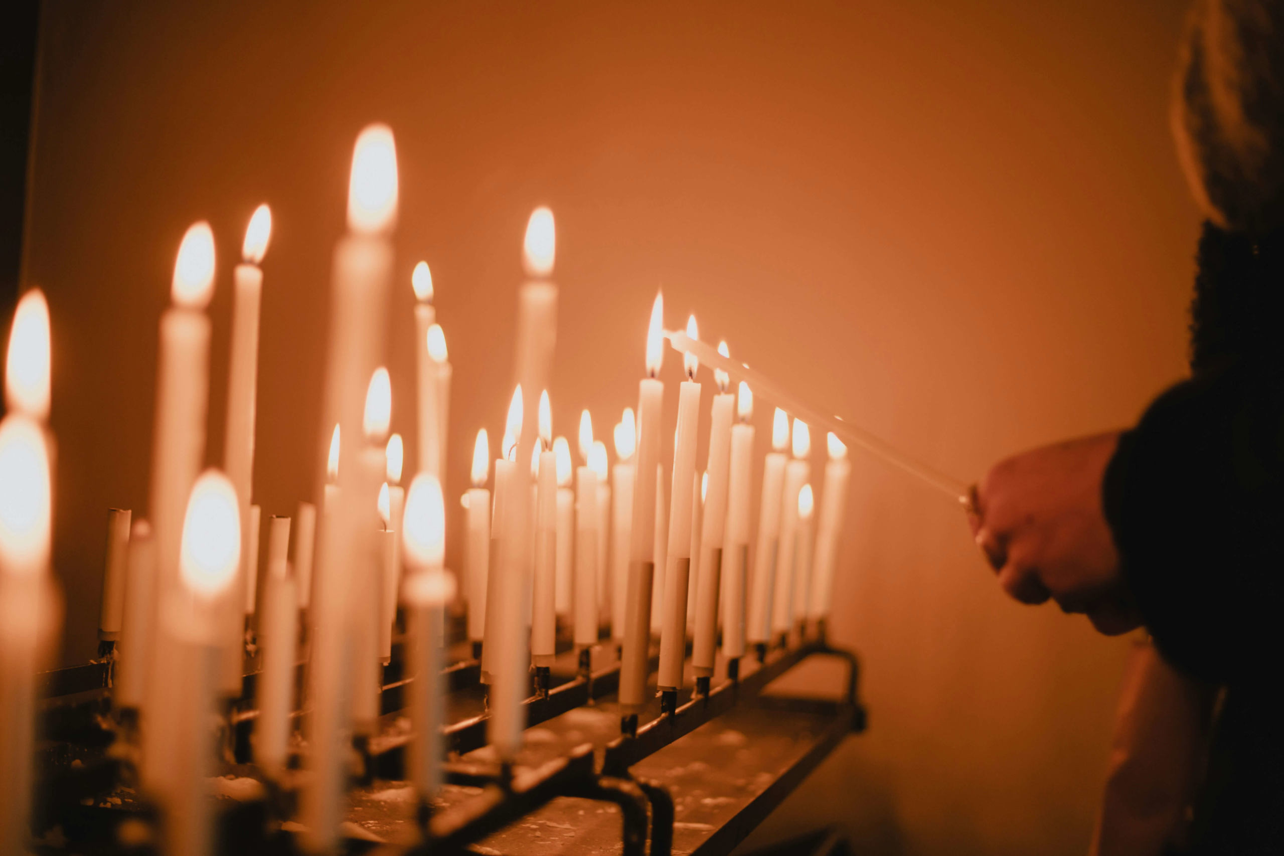 Image of someone standing in front of multiple lit candles. If you struggle with religious trauma in Austin, TX, discover how a trauma therapist can help you.